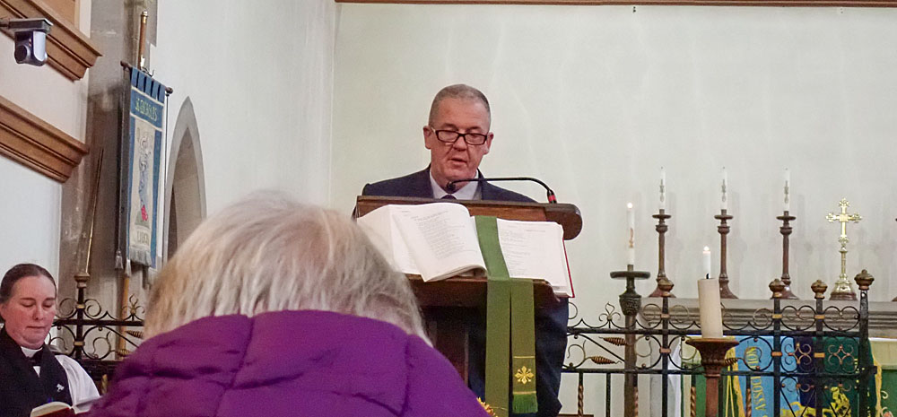 11. Chairman, Wayne Bramwell, reading the first lesson.