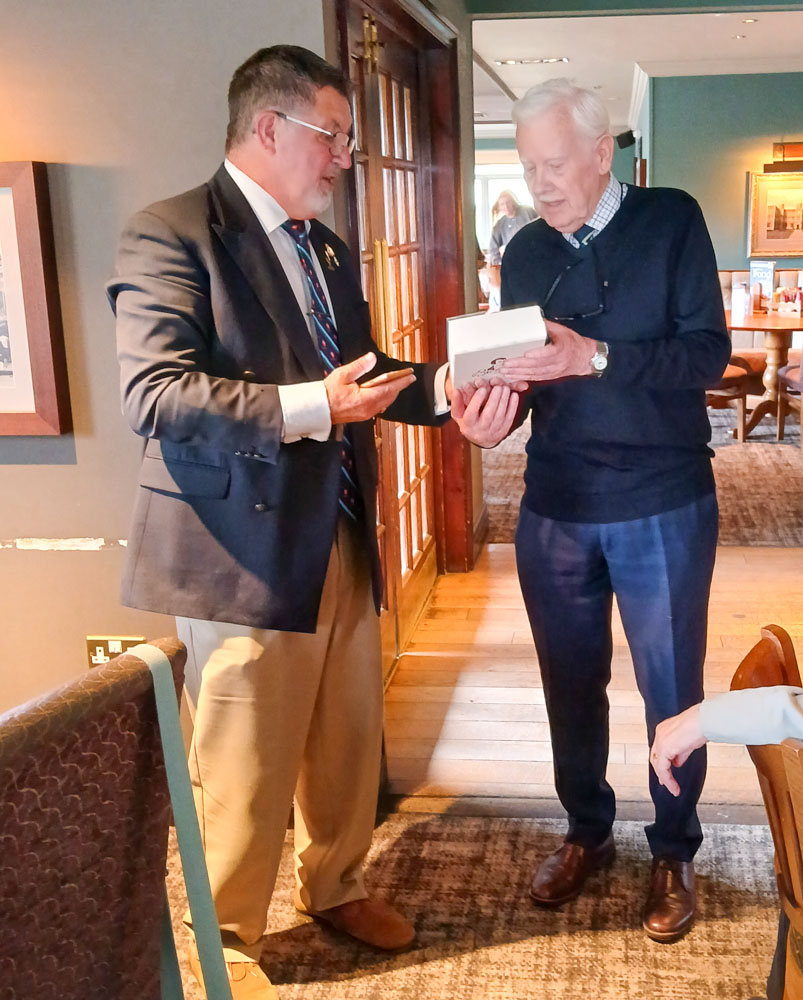 Granville presents John with a gift from the branch